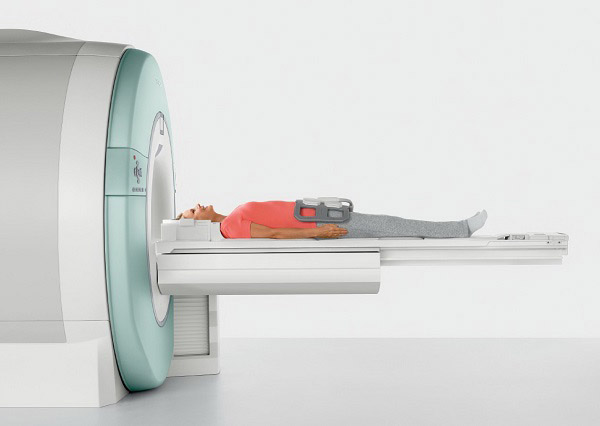 Пациент лежит на подвижном столе перед отверстием сканирующего блока томографа