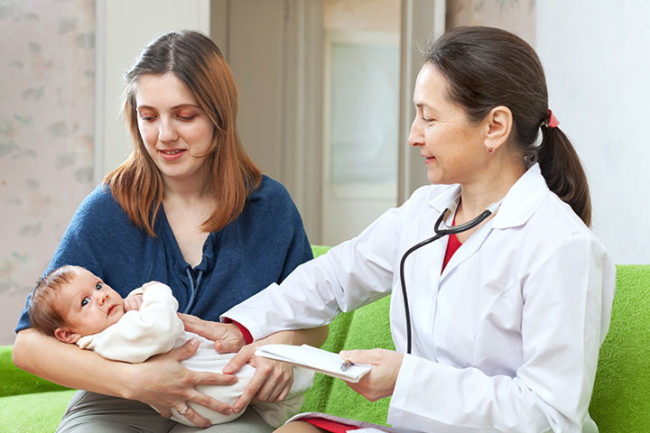 Женщина с новорождённым у врача