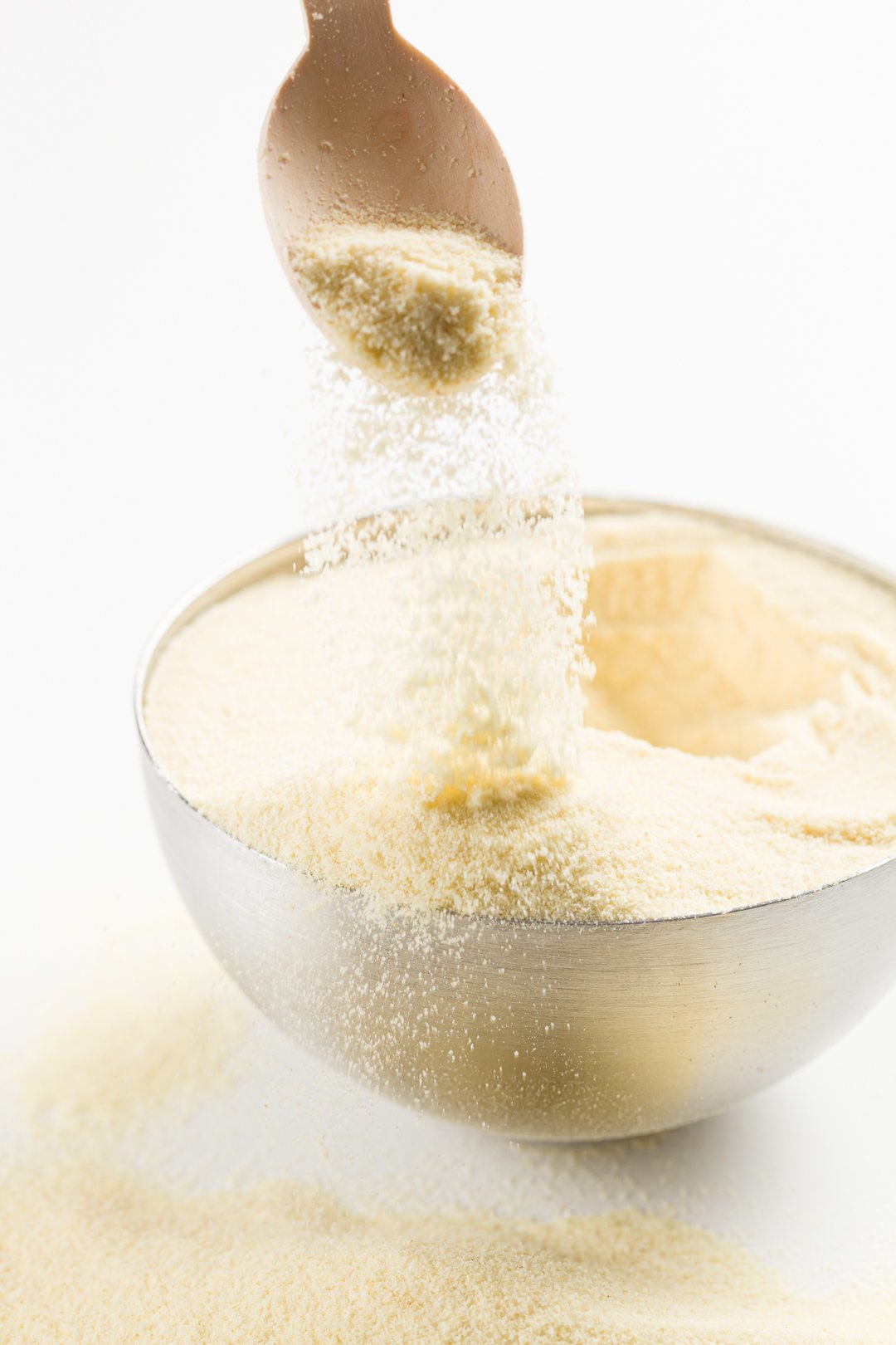 semolina flour pouring out of a spoon into a bowl