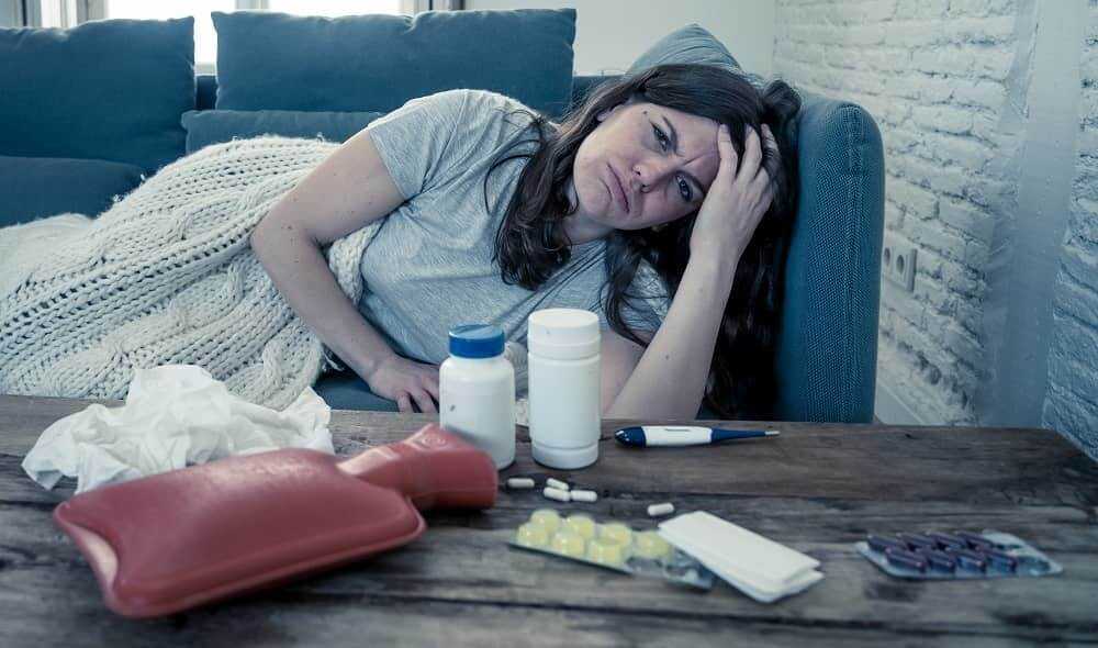 Женщина пытается вылечить приступ мигрени таблетками