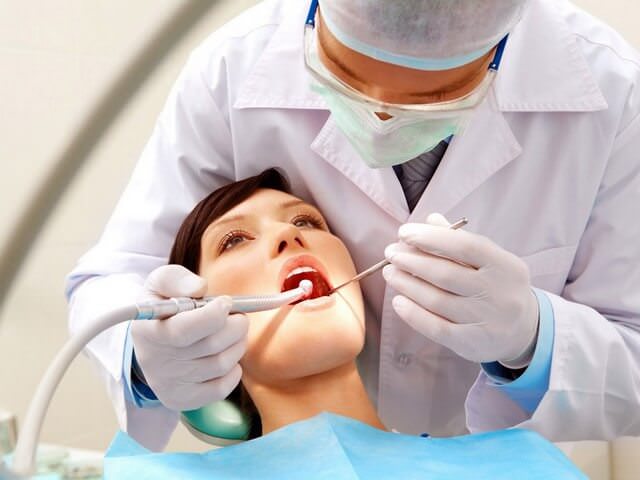 Стоматолог осматривает полость рта